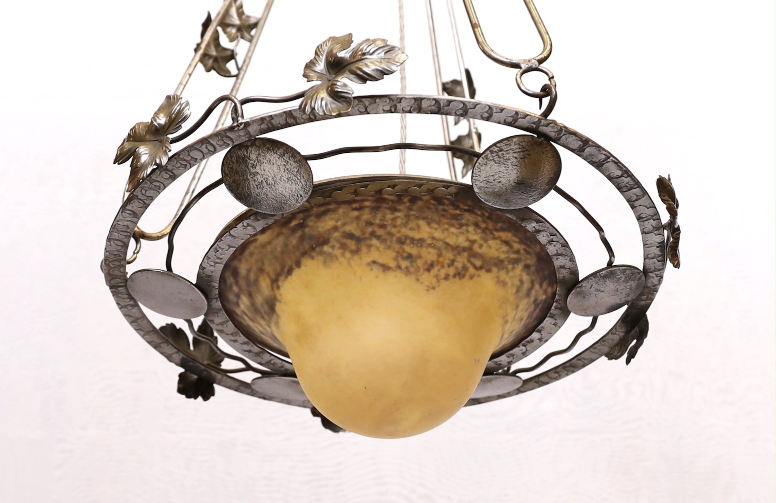 A 1920's-30's French polished wrought iron and marbled glass light fitting decorated with foliate motifs, drop 90cm, width 40cm